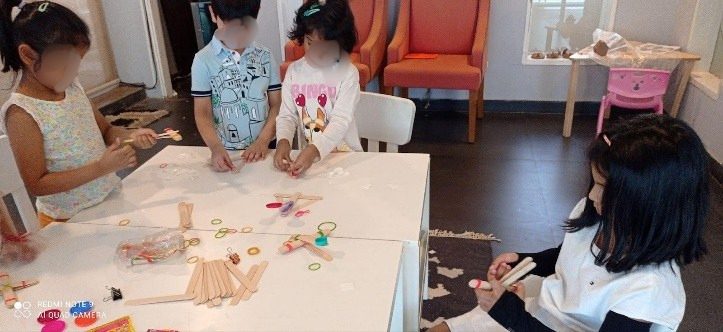 Children building lever models with popsicle sticks