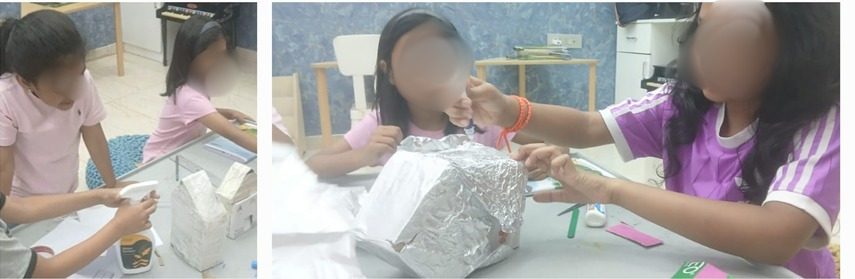 Children building lunar lander models